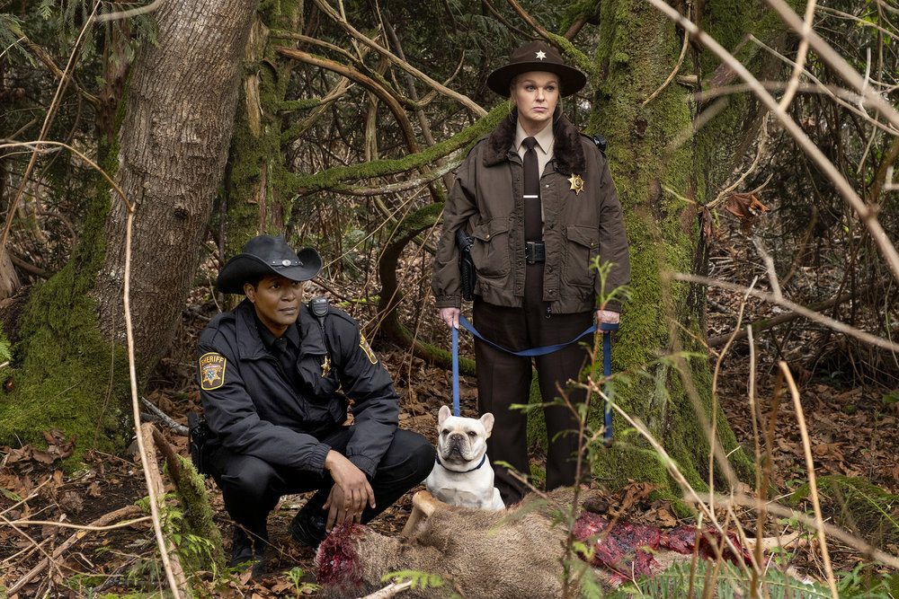 RESIDENT ALIEN -- "Daddy Issues" Episode 407 -- Pictured: (l-r) Corey Reynolds as Sheriff Mike Thompson, Elizabeth Bowen as Deputy Liv Baker