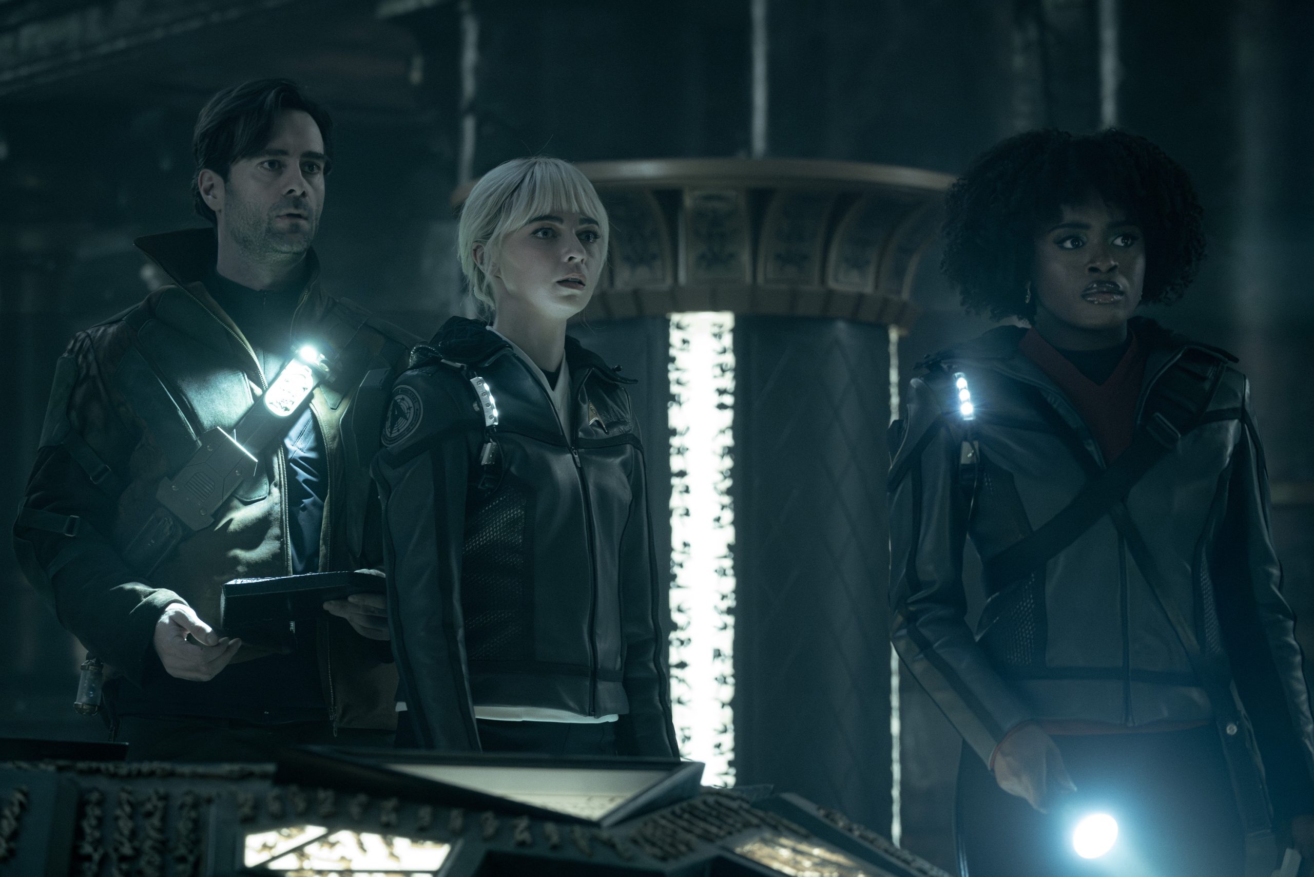 L to R Cillian O'Sullivan as Dr. Roger Korby, Jess Bush as Chapel and Celia Rose Gooding as Uhura in season 3 , Episode 5 of Strange New Worlds